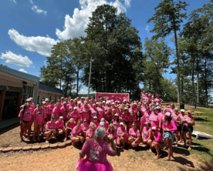 Large group of women all wearing pink 6th Annual Hartwell Lake Ladies Jet Ski Crawl t shirts, gathered together outside during the event.